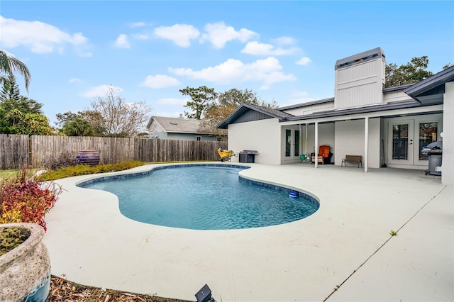 view of pool featuring a fenced in pool, french doors, grilling area, a patio area, and a fenced backyard