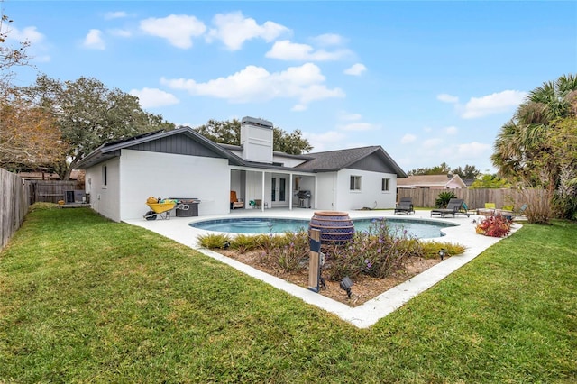 back of property featuring french doors, a patio area, a lawn, and a fenced backyard