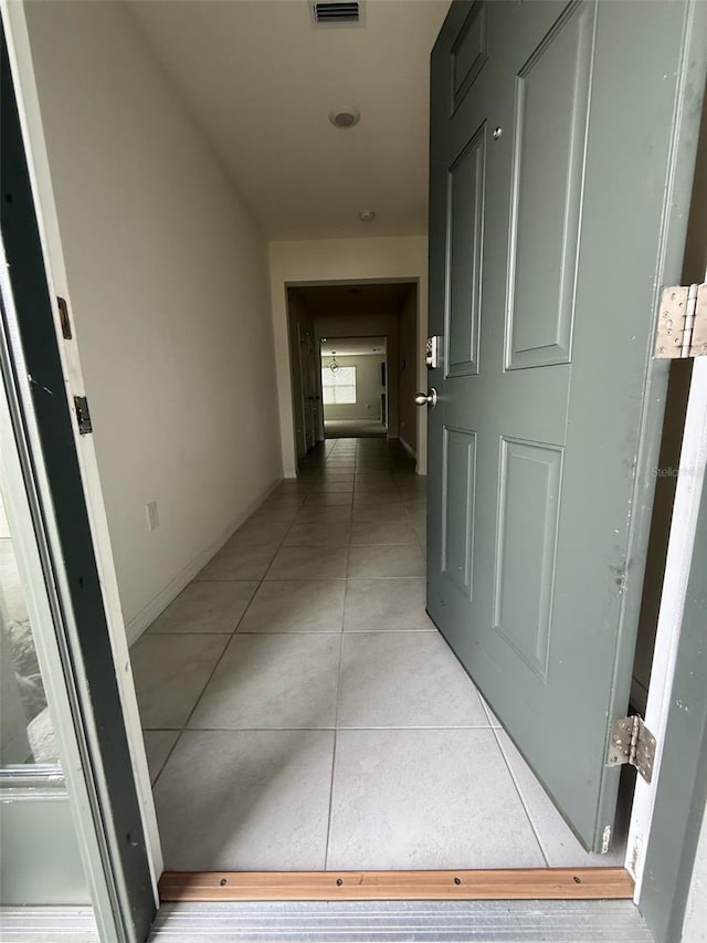 hall featuring visible vents and light tile patterned flooring