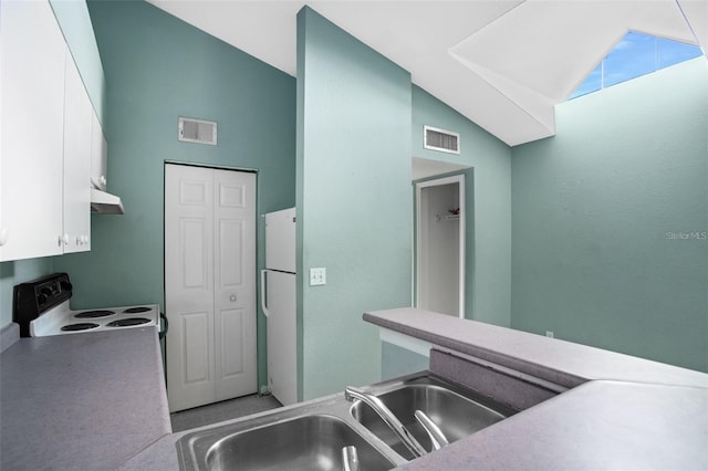 kitchen featuring a sink, visible vents, electric stove, and freestanding refrigerator