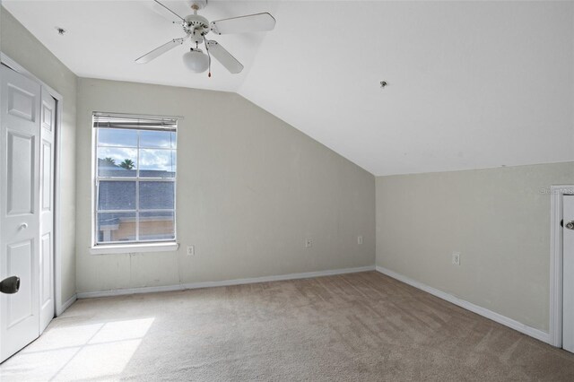 additional living space with light carpet, baseboards, vaulted ceiling, and a ceiling fan