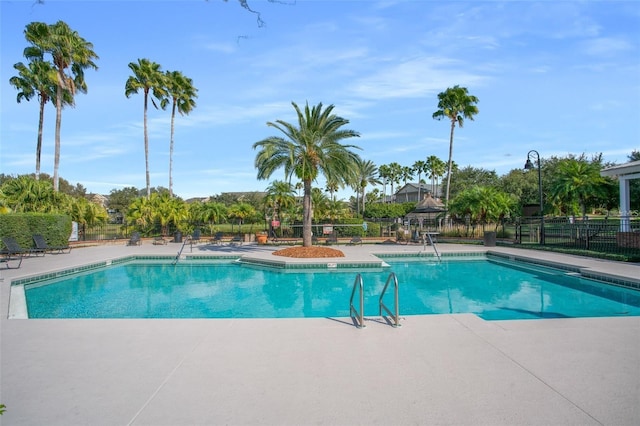 pool with a patio area and fence