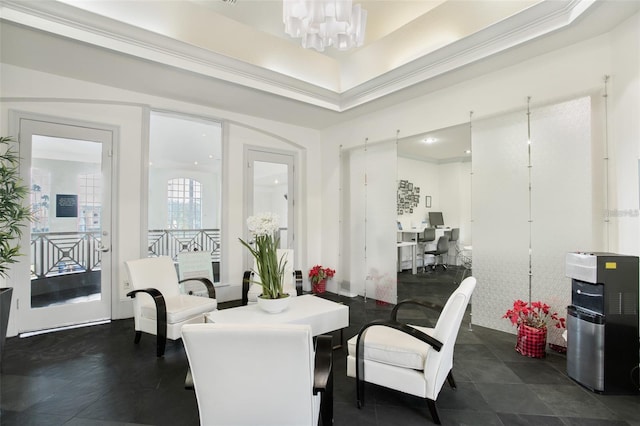 dining room featuring an inviting chandelier, a raised ceiling, and crown molding