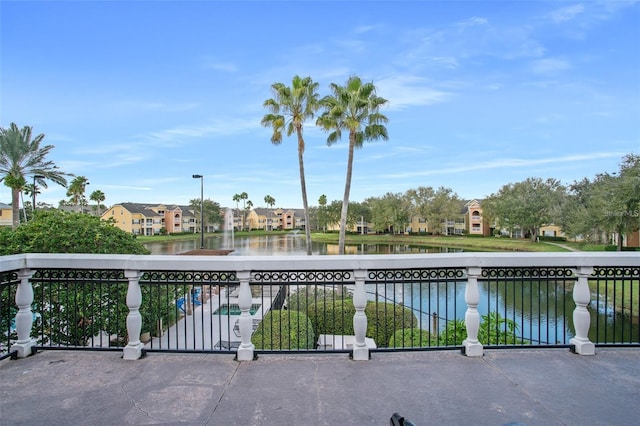 view of patio / terrace with a residential view, a water view, and a balcony