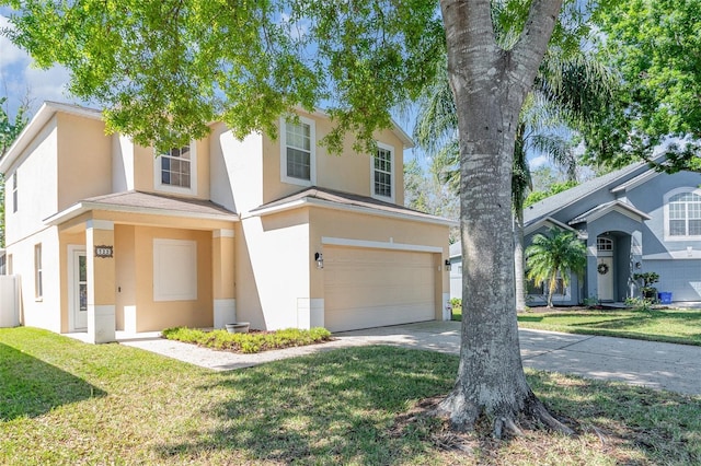 view of front of home with a garage, a front yard, concrete driveway, and stucco siding