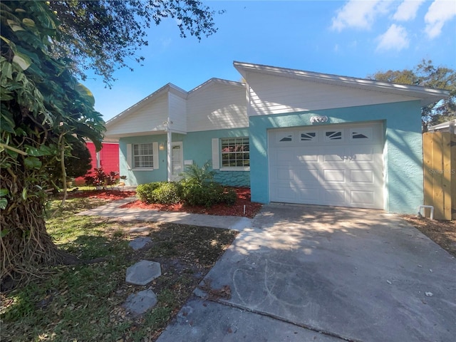 view of front of house featuring concrete driveway, an attached garage, and stucco siding