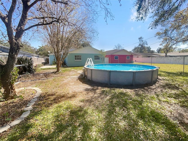 view of pool featuring a lawn, fence, and a fenced in pool