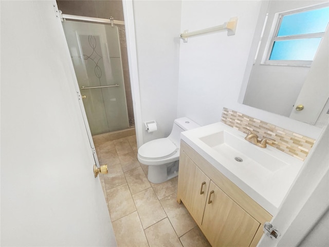 bathroom featuring toilet, a stall shower, backsplash, and vanity