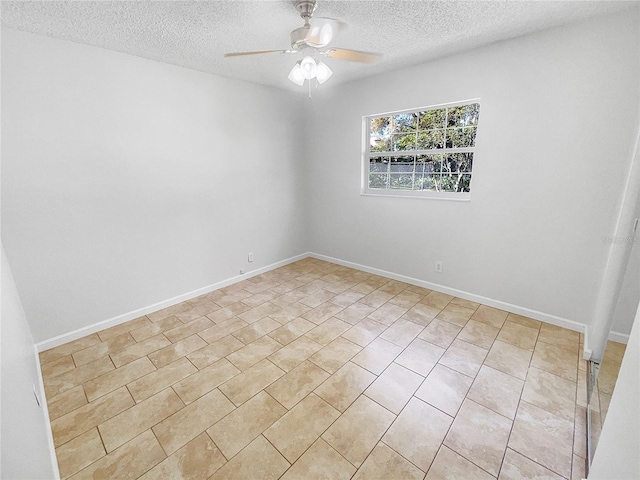 empty room with a textured ceiling, a ceiling fan, and baseboards