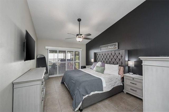 bedroom with vaulted ceiling, light tile patterned floors, and a ceiling fan