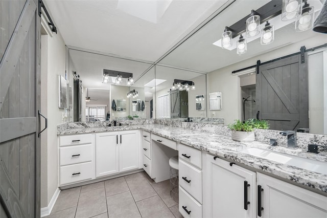 bathroom featuring double vanity, a sink, a shower stall, and tile patterned floors