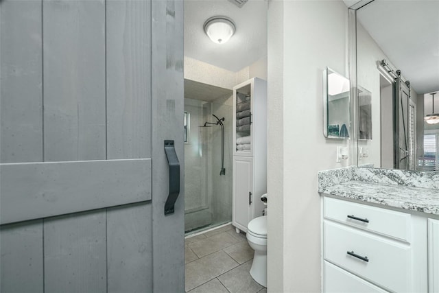 full bathroom featuring vanity, a stall shower, tile patterned flooring, and toilet