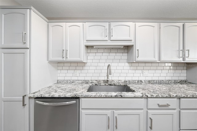 kitchen with stainless steel dishwasher, a sink, light stone counters, and tasteful backsplash