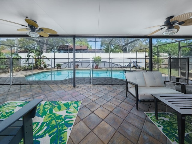 view of swimming pool featuring a ceiling fan, a patio, glass enclosure, a fenced backyard, and an outdoor living space