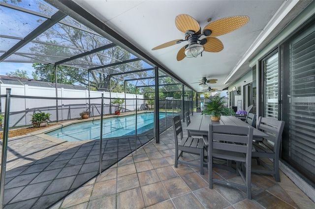 view of pool with a ceiling fan, glass enclosure, a patio area, and a fenced backyard