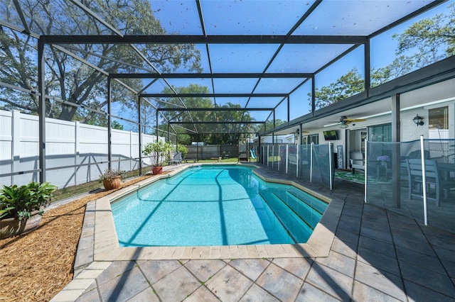 view of swimming pool with a patio area, a fenced backyard, and glass enclosure