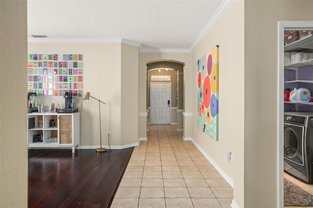 12824 Penshurst Ln, Windermere, FL 34786 - hallway featuring washer / clothes dryer, arched walkways, crown molding, and tile patterned floors
