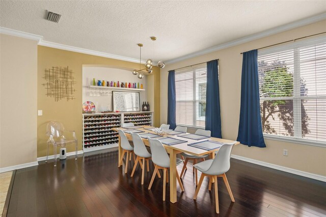 12824 Penshurst Ln, Windermere, FL 34786 - dining area featuring a textured ceiling, wood-type flooring, baseboards, and crown molding