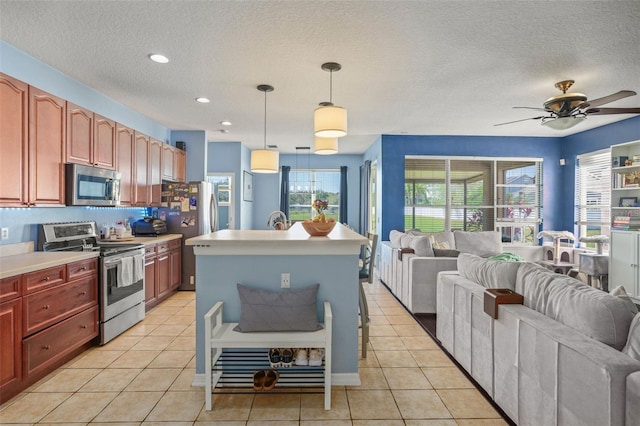 12824 Penshurst Ln, Windermere, FL 34786 - kitchen featuring light tile patterned floors, appliances with stainless steel finishes, open floor plan, and light countertops