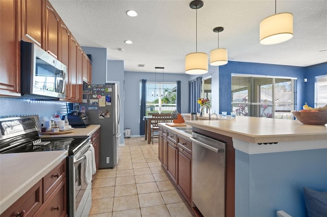 12824 Penshurst Ln, Windermere, FL 34786 - kitchen featuring light tile patterned floors, stainless steel appliances, a sink, light countertops, and pendant lighting