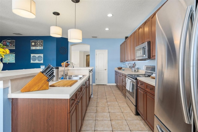 12824 Penshurst Ln, Windermere, FL 34786 - kitchen featuring light tile patterned floors, brown cabinets, stainless steel appliances, light countertops, and a sink