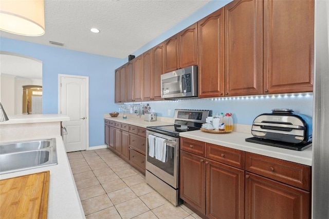 12824 Penshurst Ln, Windermere, FL 34786 - kitchen with light tile patterned floors, visible vents, appliances with stainless steel finishes, and light countertops