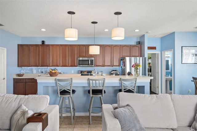 12824 Penshurst Ln, Windermere, FL 34786 - kitchen with light tile patterned floors, appliances with stainless steel finishes, open floor plan, light countertops, and pendant lighting