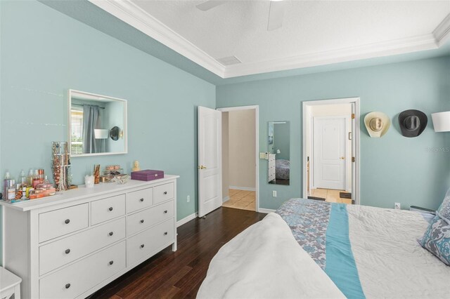 12824 Penshurst Ln, Windermere, FL 34786 - bedroom with baseboards, dark wood finished floors, a ceiling fan, a raised ceiling, and crown molding