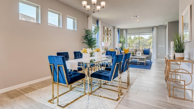 dining room with a notable chandelier, visible vents, and baseboards