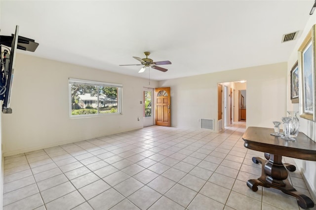 spare room with light tile patterned floors, baseboards, visible vents, and a ceiling fan