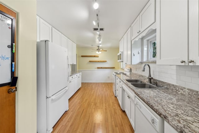 kitchen with white appliances, a sink, white cabinetry, visible vents, and decorative backsplash