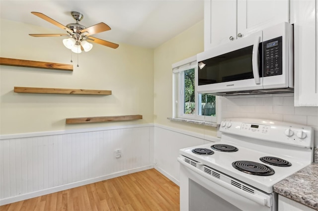 kitchen featuring a wainscoted wall, open shelves, white cabinetry, light wood-type flooring, and white appliances