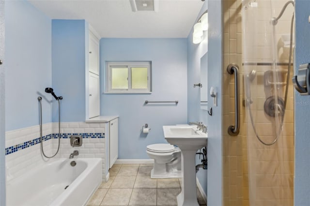 bathroom with a garden tub, toilet, a sink, tile patterned floors, and a stall shower