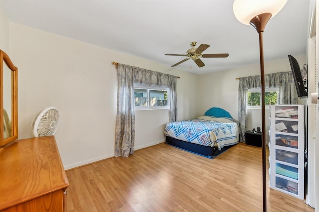 bedroom featuring ceiling fan, baseboards, and wood finished floors