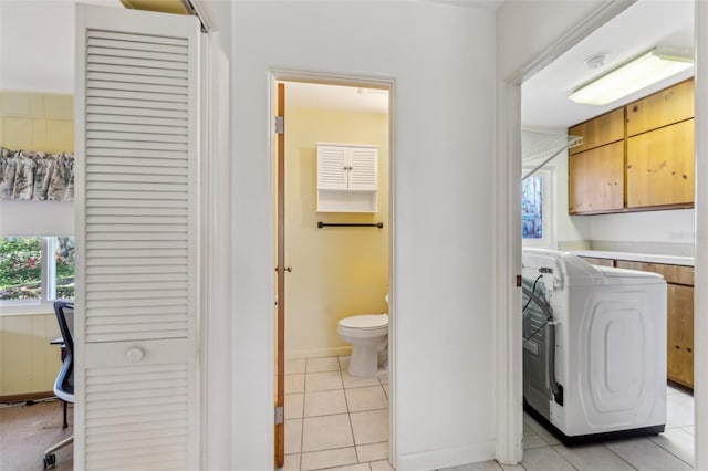 laundry area featuring cabinet space, washer and clothes dryer, and light tile patterned flooring