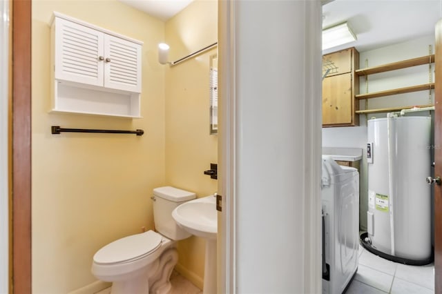 bathroom with electric water heater, toilet, tile patterned flooring, and washer / dryer