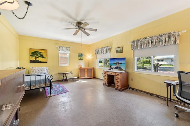 interior space featuring finished concrete flooring, ceiling fan, and baseboards