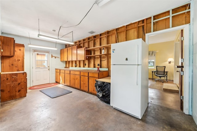 kitchen featuring concrete flooring, open shelves, visible vents, and freestanding refrigerator