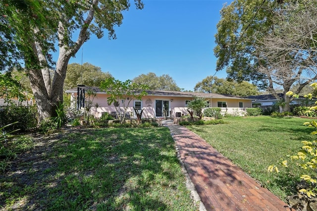 ranch-style home with a front lawn and stucco siding