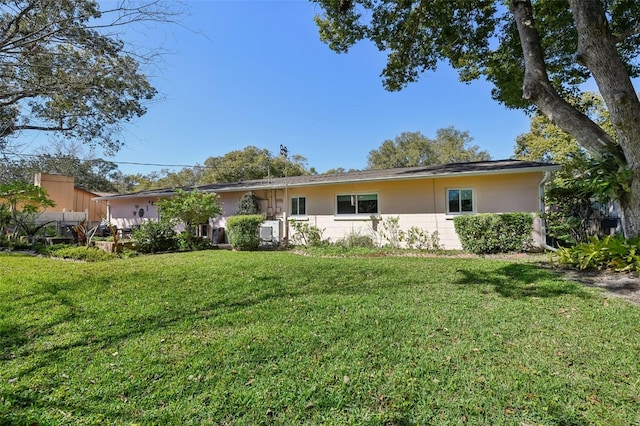 view of front of property featuring concrete block siding and a front lawn