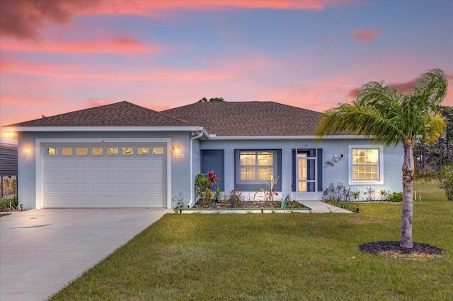 single story home featuring a front yard, concrete driveway, an attached garage, and stucco siding