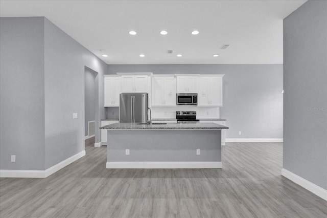 kitchen featuring appliances with stainless steel finishes, white cabinets, a kitchen island with sink, and a sink