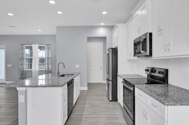 kitchen featuring recessed lighting, an island with sink, white cabinets, appliances with stainless steel finishes, and a sink