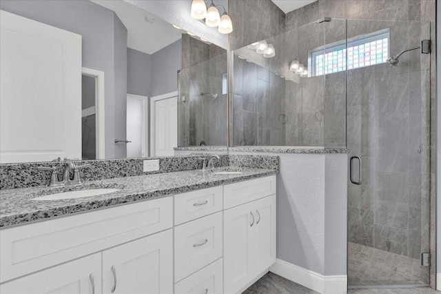 bathroom featuring a shower stall, double vanity, and a sink