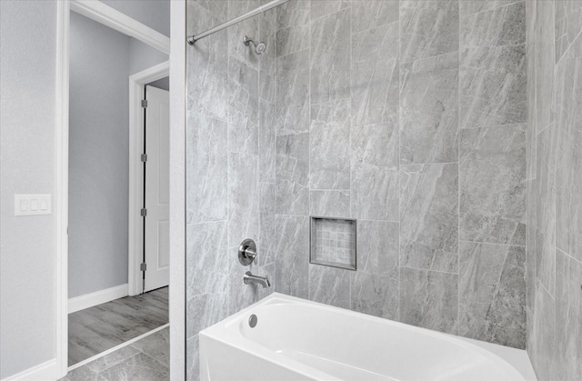 bathroom with baseboards and  shower combination