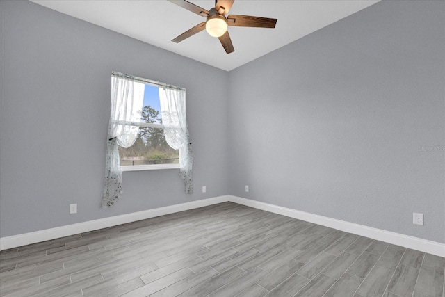 empty room with baseboards, wood finished floors, and ceiling fan