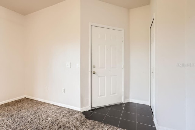 entrance foyer featuring dark tile patterned flooring and baseboards