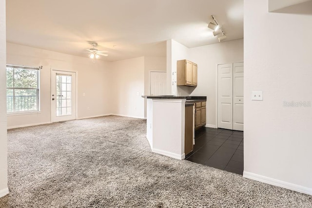 kitchen with a ceiling fan, baseboards, dark carpet, light brown cabinetry, and dark countertops