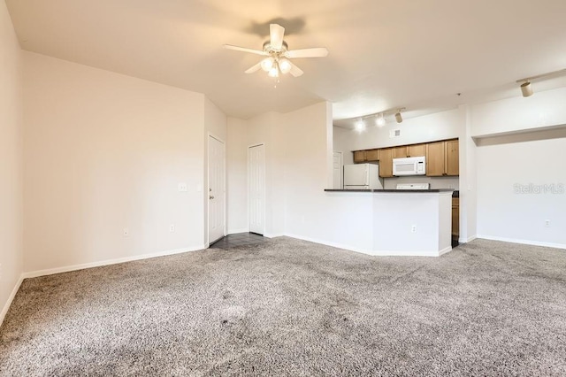 unfurnished living room with ceiling fan, track lighting, carpet flooring, and baseboards