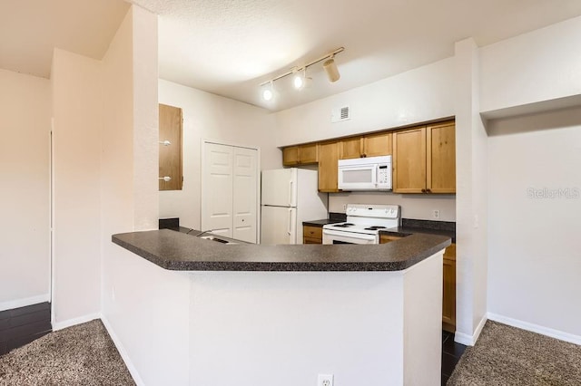 kitchen with white appliances, baseboards, visible vents, dark countertops, and a peninsula